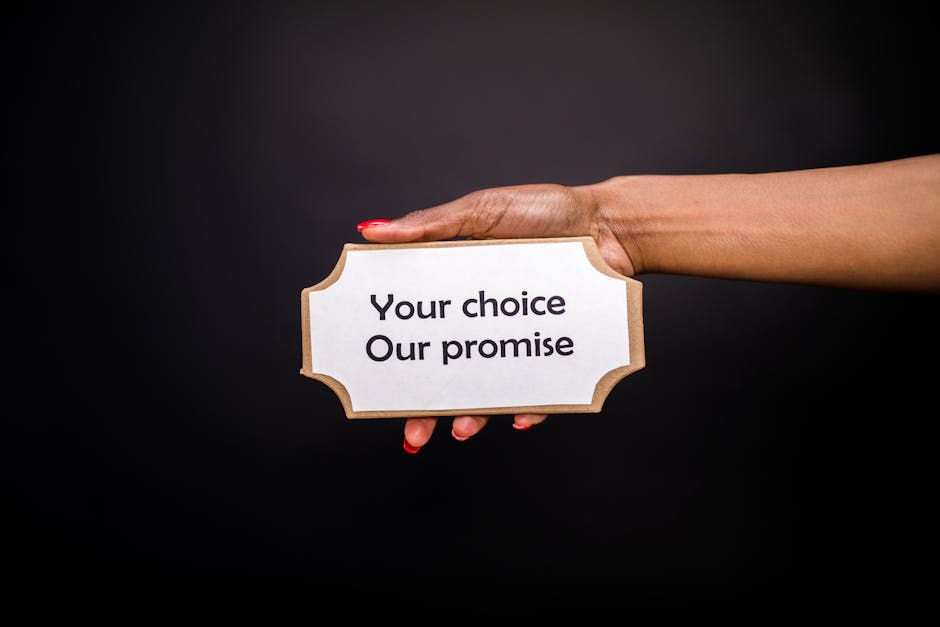 A hand holds a sign saying 'Your choice, Our promise' against a dark background.
