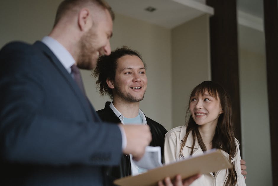 Happy young couple conversing with a realtor indoors about a new apartment.